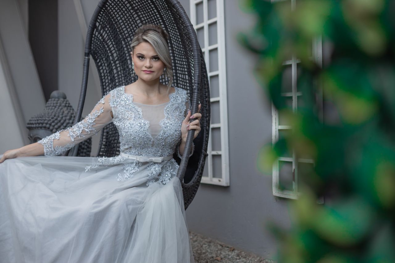 Services-02 Beautiful bride in a lace wedding gown seated outdoors, showcasing elegance and bridal fashion.